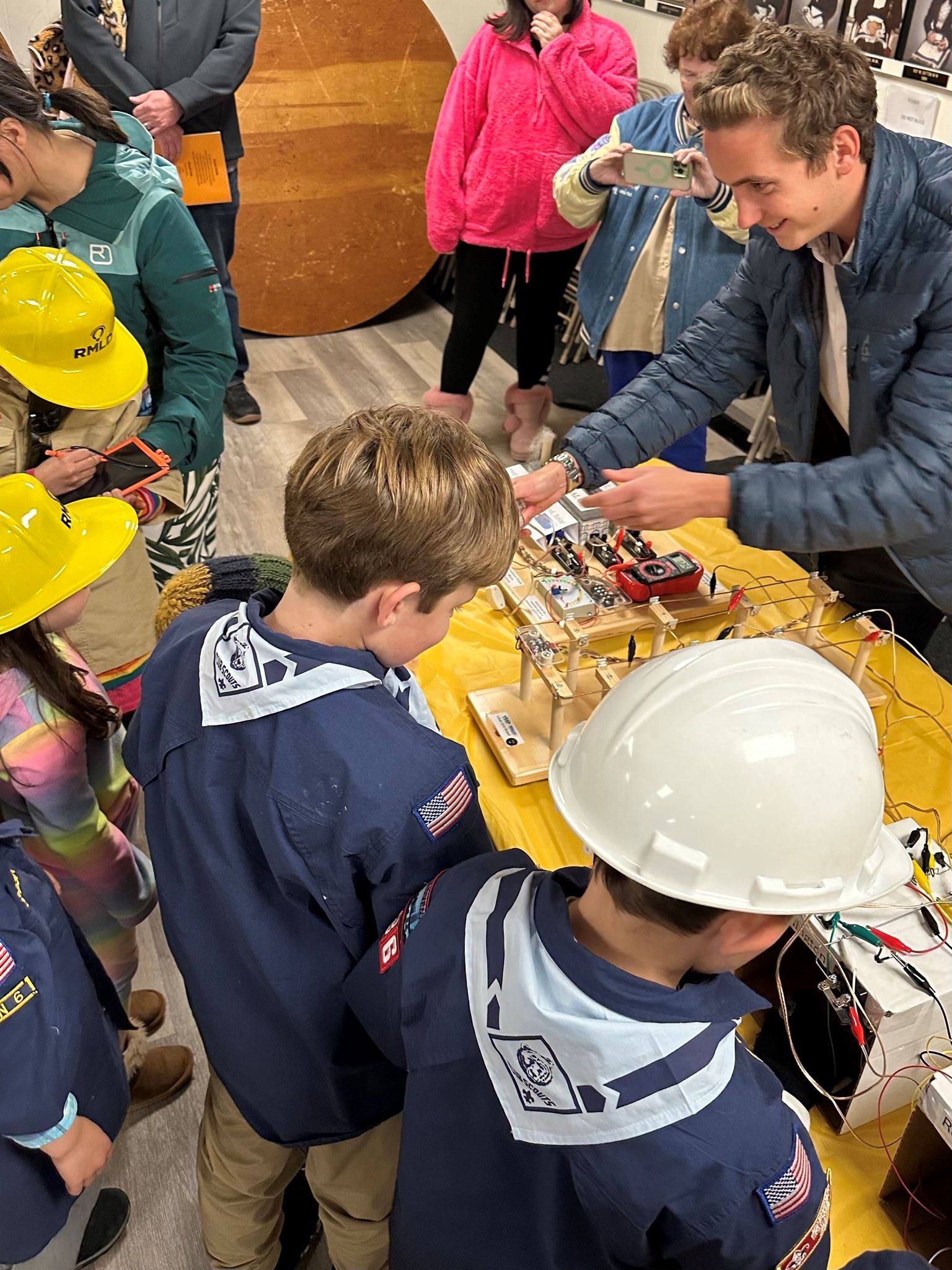 An employee guides cub scout members in a model grid demonstration.